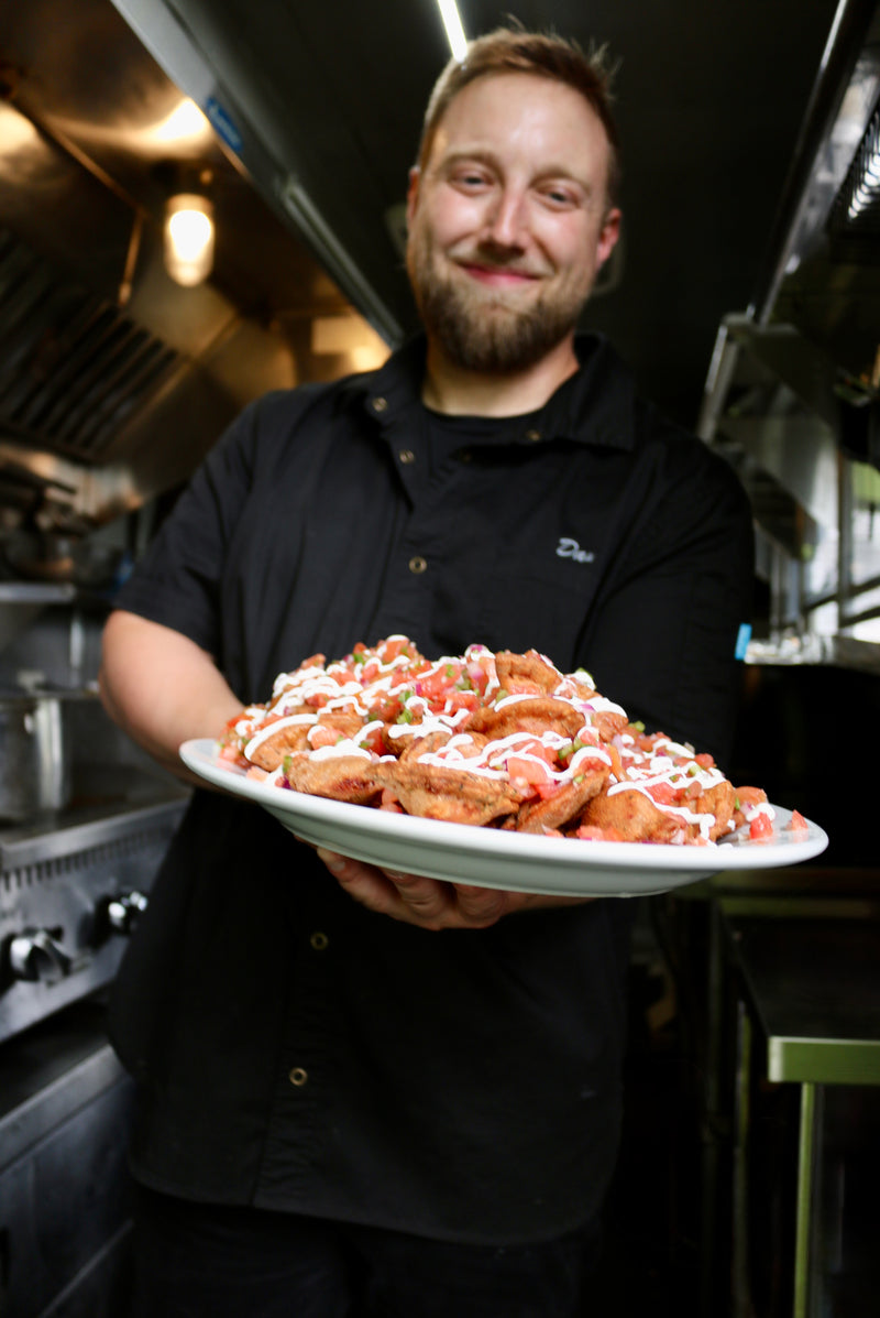 Person holding a plate of food in a kitchen setting